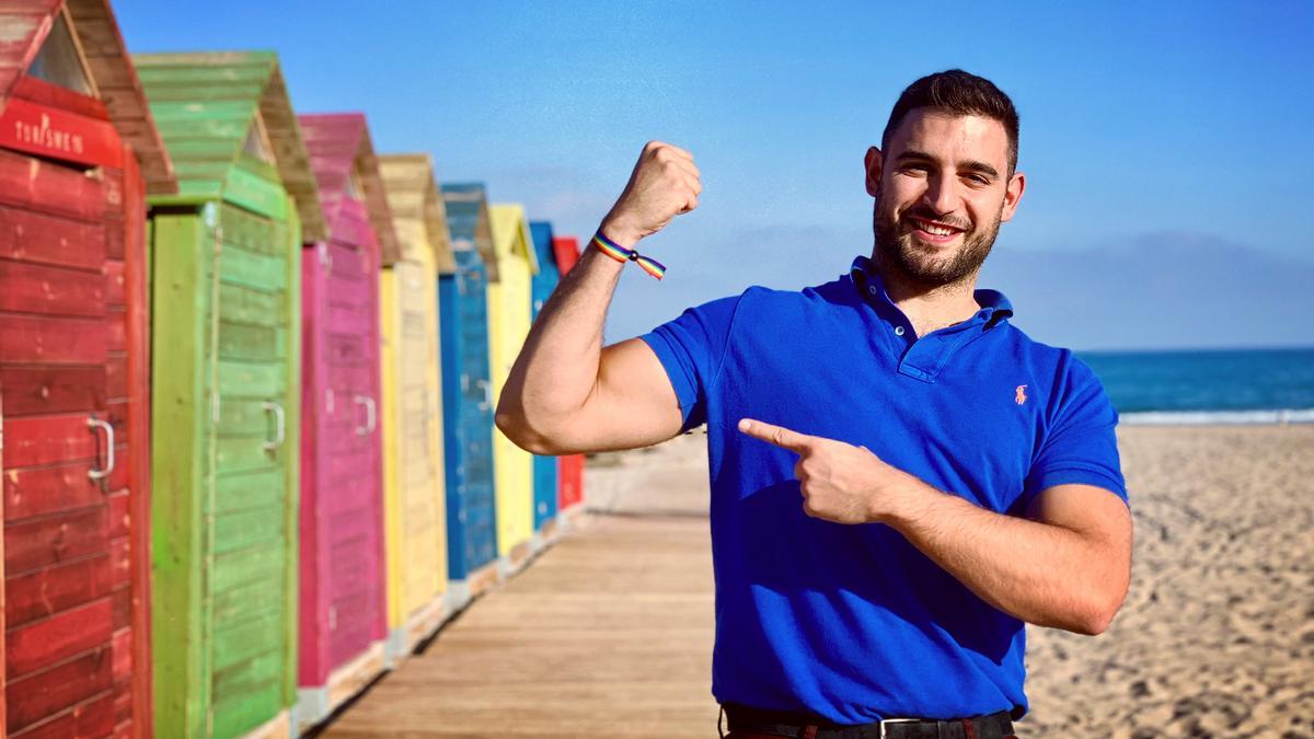 Francisco Alvarado, el médico cacereño y Mr Gay World 2020, posa en la playa junto a casas de colores.