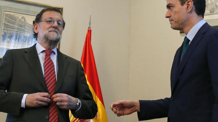 Sánchez intentant donar la mà a Rajoy mentre aquest es corda l&#039;americana.