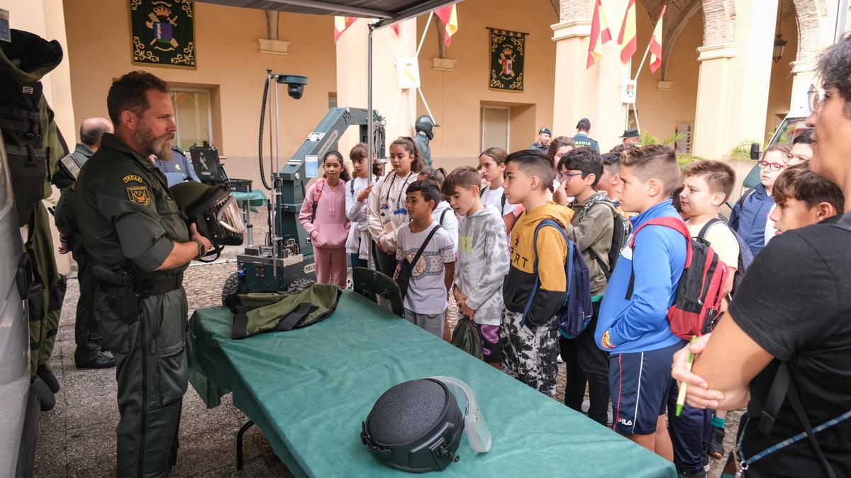 Un agente de los Tedax explica a los niños cuál es su labor y que equipos utilizan, este lunes en la comandancia de la Guardia Civil en Badajoz.