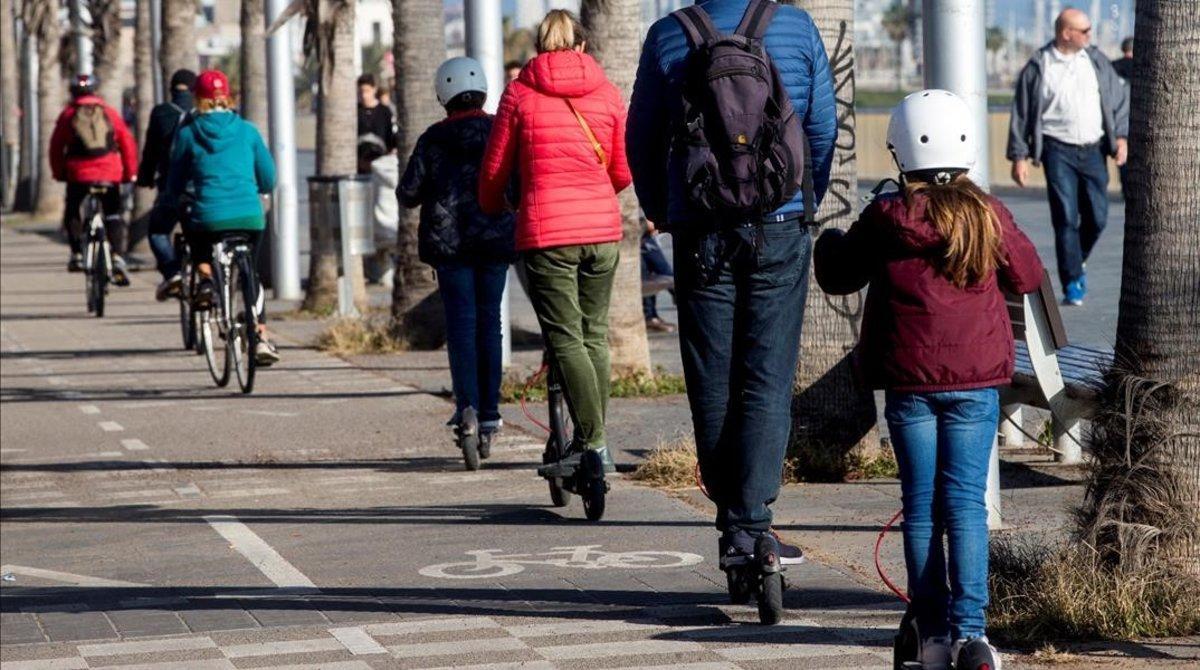 Una familia circula con patinetes eléctricos.