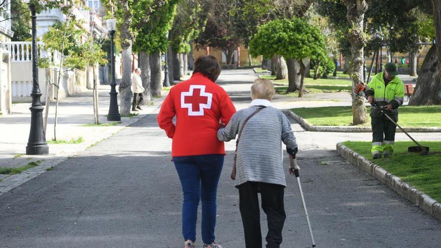 Una voluntaria de Cruz Roja acompaña a una mujer dependiente.