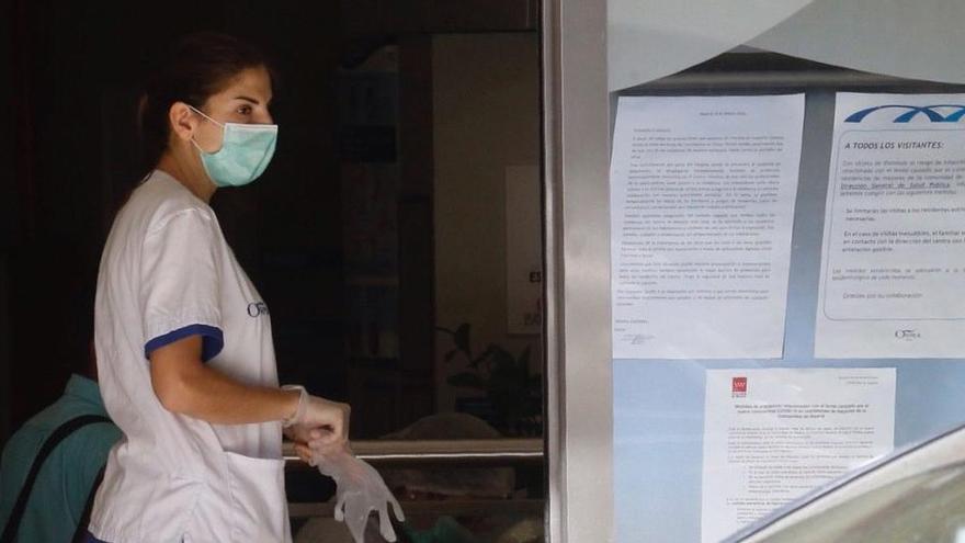 Una mujer con una mascarilla entra en una residencia de mayores en Madrid.