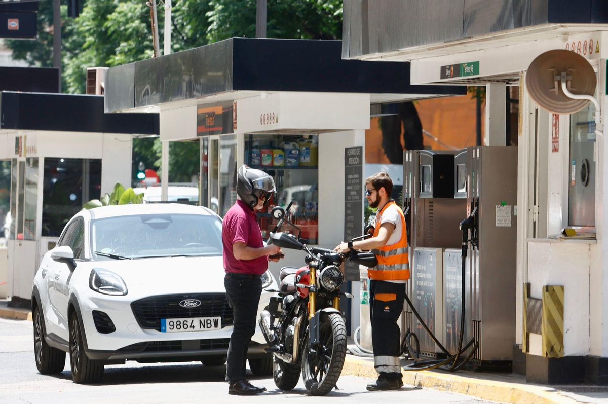 A motorcycle and a car at a Valencian service station, this morning.