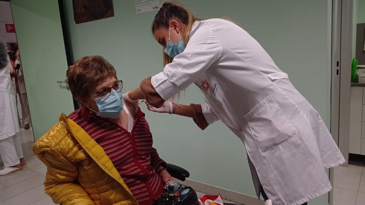 Una enfermera vacuna a una vecina de La Almozara contra la gripe.