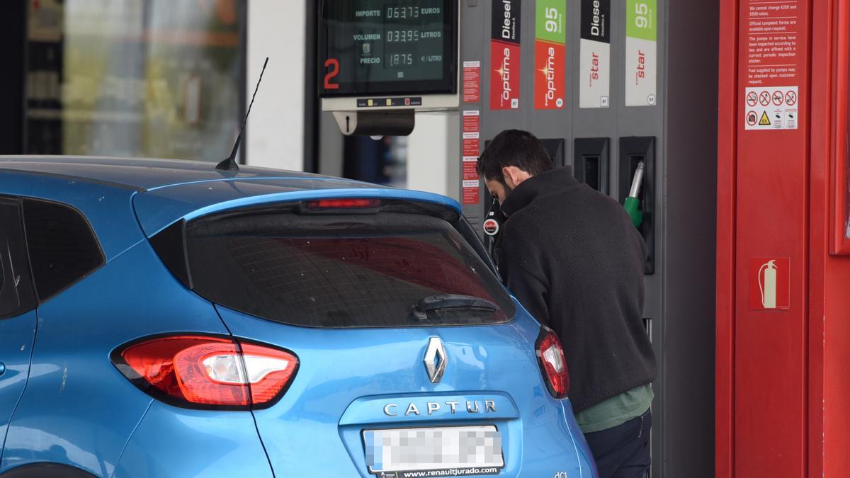 Un hombre echa gasolina a su vehículo en una estación de servicio. Nueva predicción en los precios de la gasolina