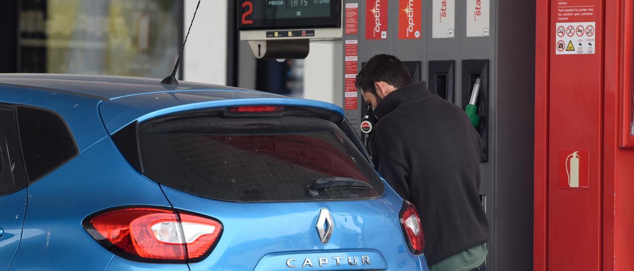 Un hombre echa gasolina a su vehículo en una estación de servicio.