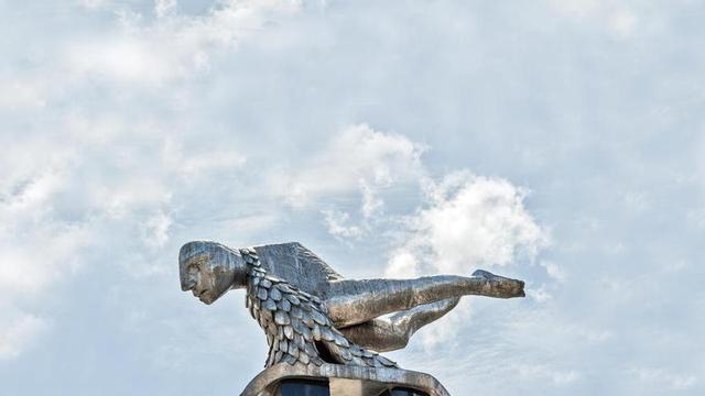 La figura de El Sireno en primer plano con el cielo de Vigo de fondo. // EliRegueira