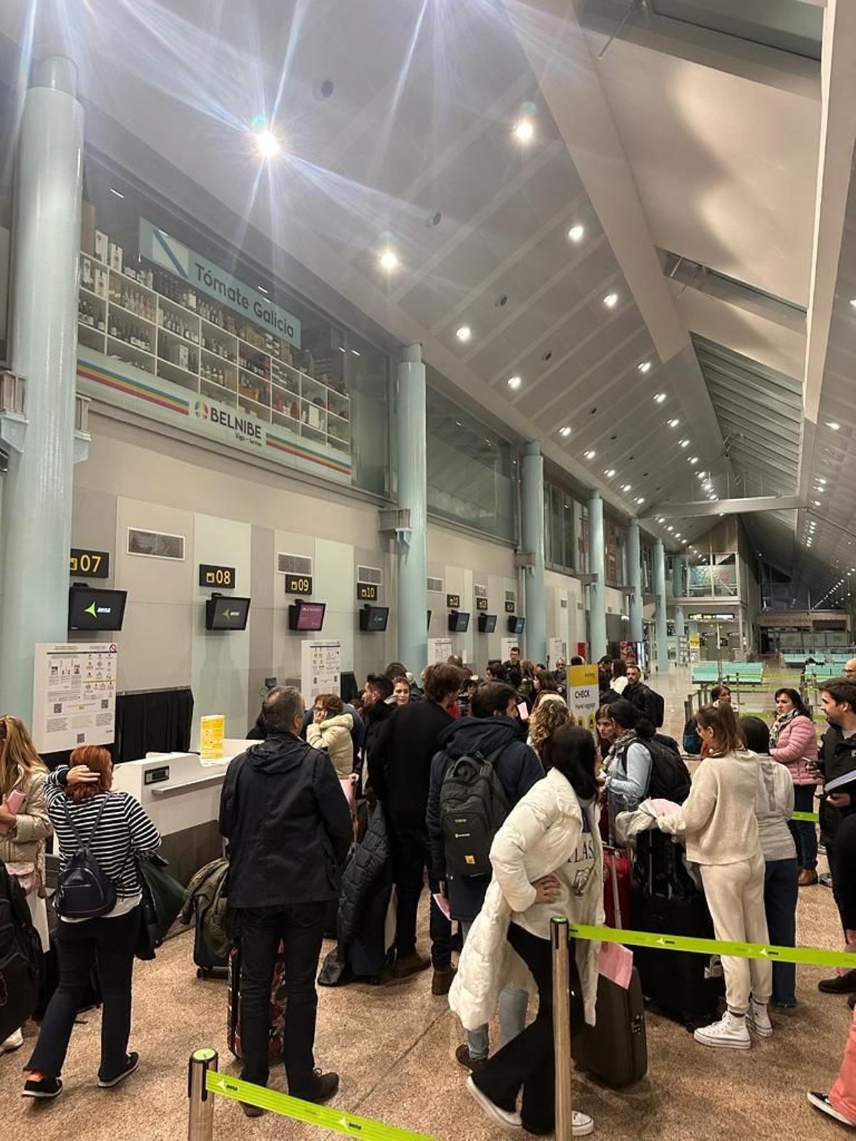 Pasajeros en el aeropuerto de Peinador tras la salida de su avión con los futbolistas del Sevilla.