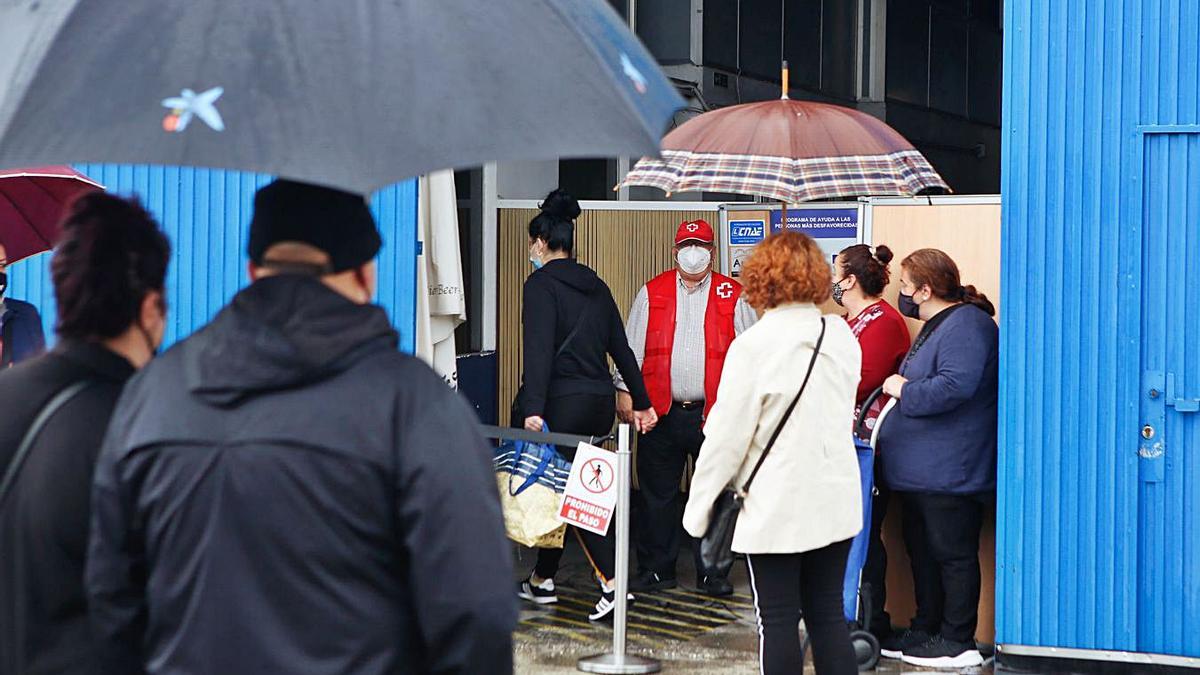 Cola de personas acuden a Cruz Roja para recibir alimentos.