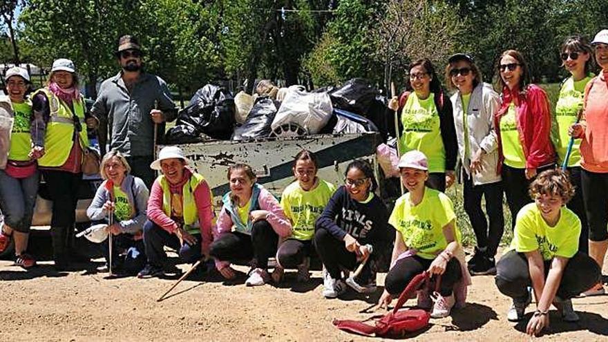 Grupo de voluntarios que han recogido residuos en el entorno de Fuentesaúco, con el carro de basura.