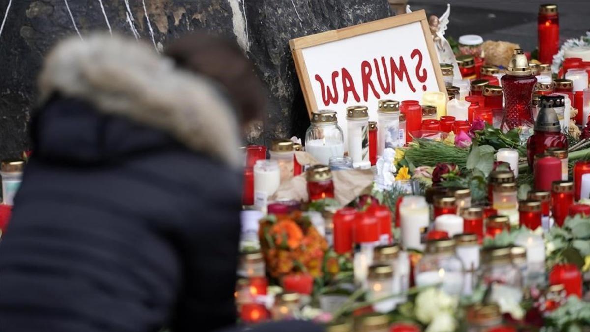 Una mujer deposita flores en el homenaje de Trier.