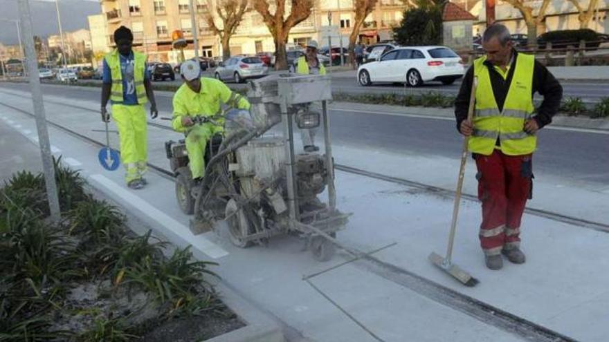 Los obreros continuaban pintando la señalización horizontal de Valle-Incán ayer por la tarde.  // Noé Parga