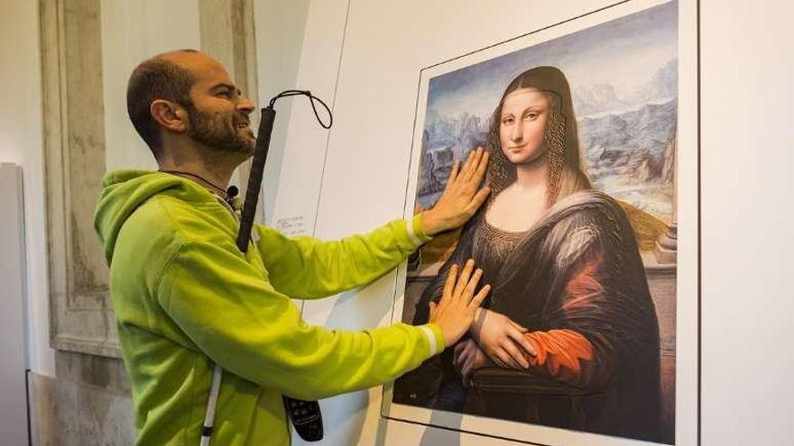 Un invidente toca uno de los cuadros de la exposición. // Museo del Prado