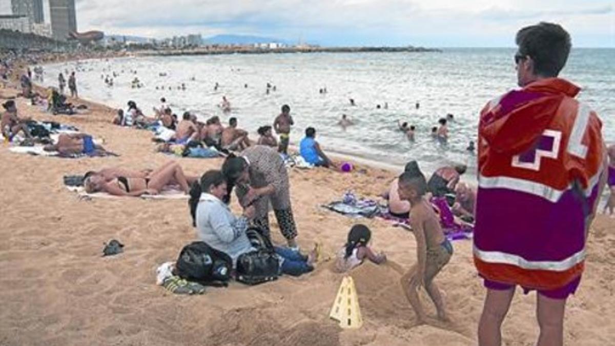 Un socorrista de la Cruz Roja otea, el viernes, la playa de la Barceloneta, sector del litoral barcelonés en el que la semana pasada se atendieron a una decena de bañistas lesionados por medusas.