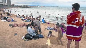 Un socorrista de la Creu Roja observa, divendres, la platja de la Barceloneta, sector del litoral barceloní en el qual la setmana passada es van atendre una desena de banyistes lesionats per meduses.