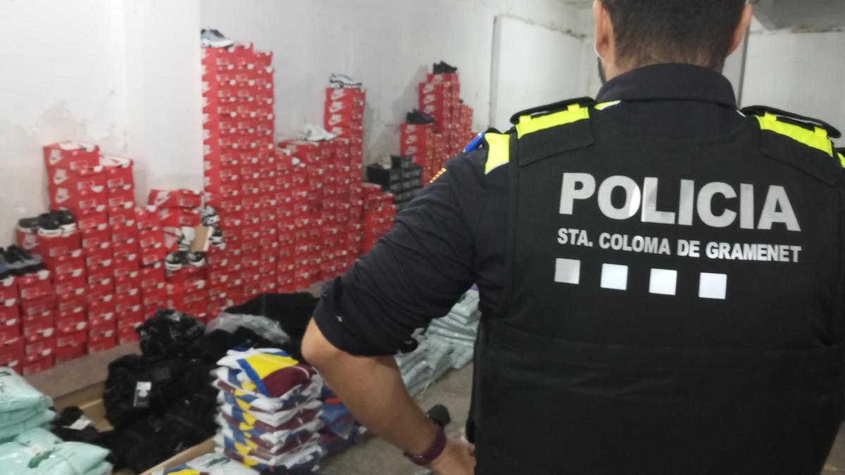 Un agente de la Policía Local de Santa Coloma, ante las prendas de ropa falsificadas