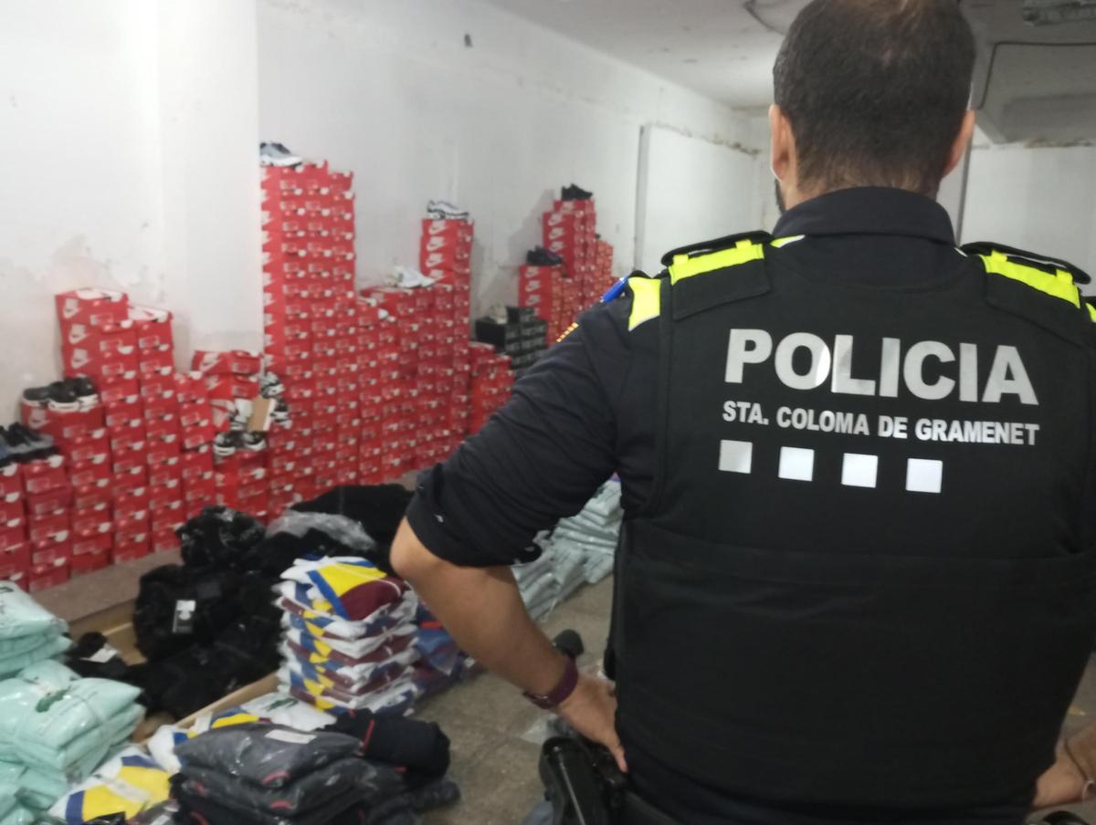 Un agente de la Policía Local de Santa Coloma, ante las prendas de ropa falsificadas Un agente de la Policía Local de Santa Coloma, ante las prendas de ropa falsificadas