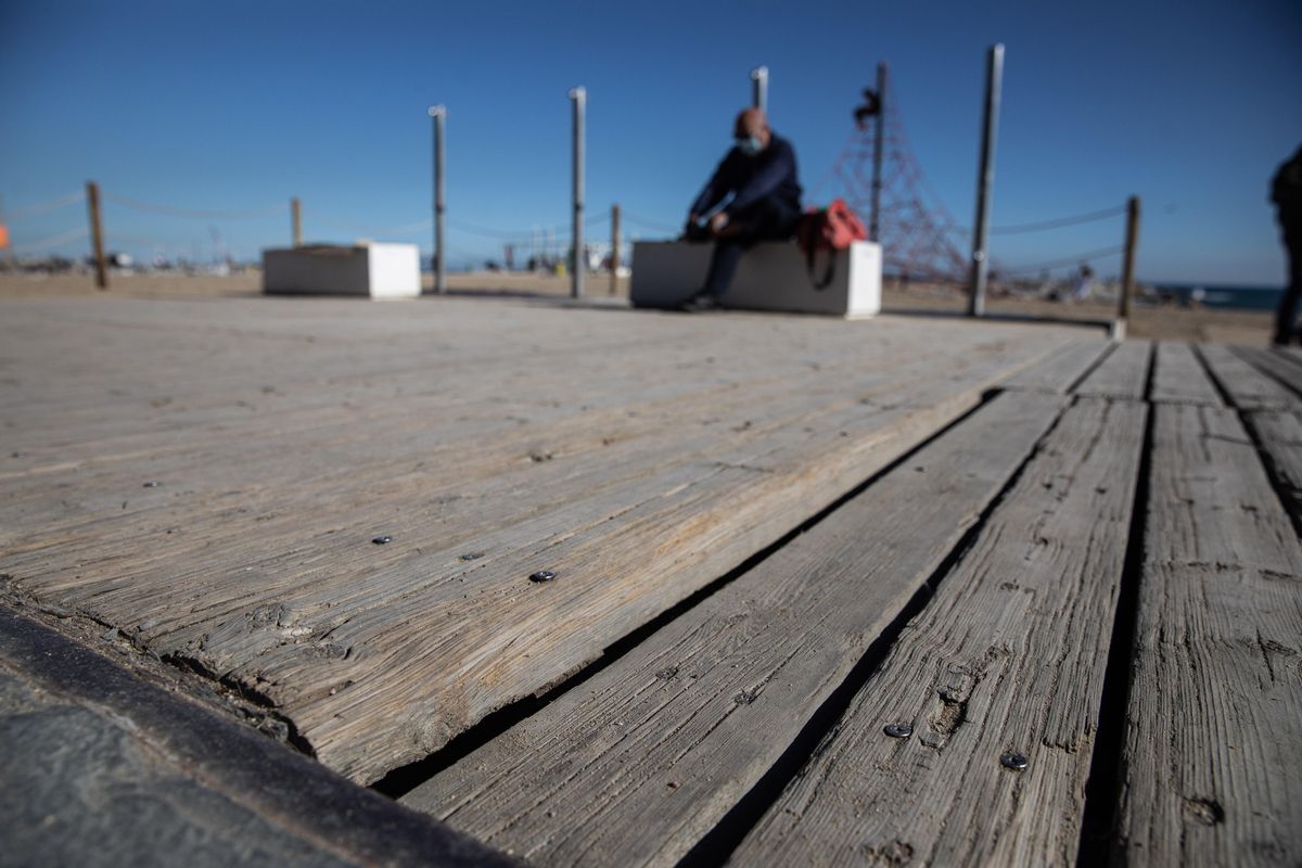 Tablas de madera en mal estado en el suelo del paseo.