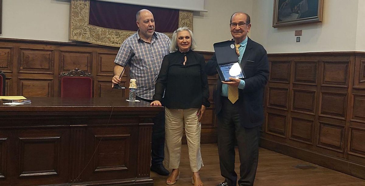 Emilio Casares muestra la placa, con Teresa Anta San Pedro y Aurelio Martínez Seco a su lado. | E. P.