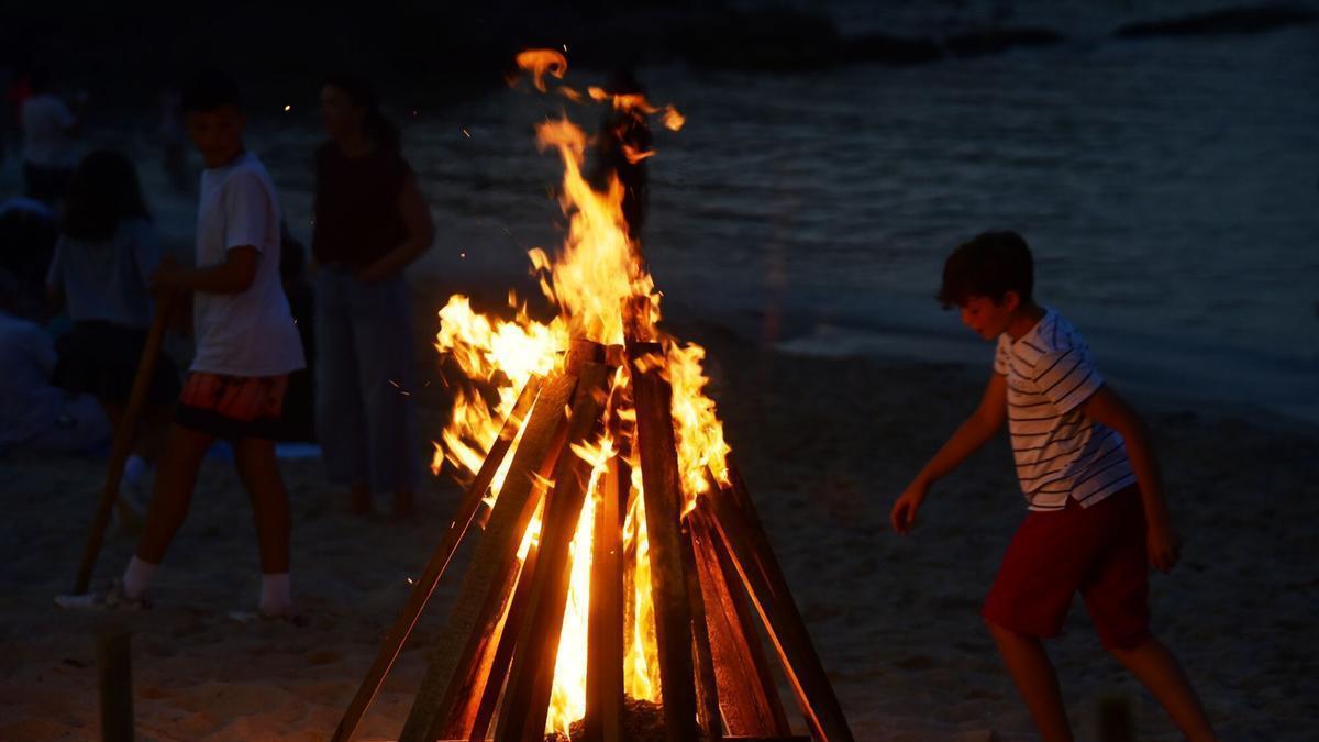 Un niño junto a una hoguera en San Juan