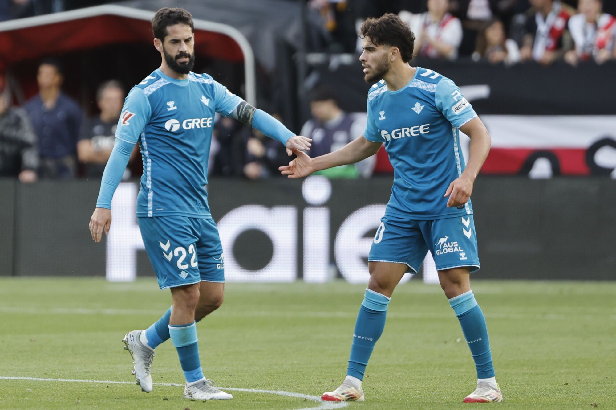 MADRID, 15/05/2025.- El centrocampista del Betis Isco (i) es felicitado tras anotar el segundo gol del equipo de penalti por Ez Abde durante el partido de la jornada 36 de LaLiga EA Sports, entre el Rayo Vallecano y el Betis, en el Estadio de Vallecas de Madrid. EFE/ Sergio Pérez