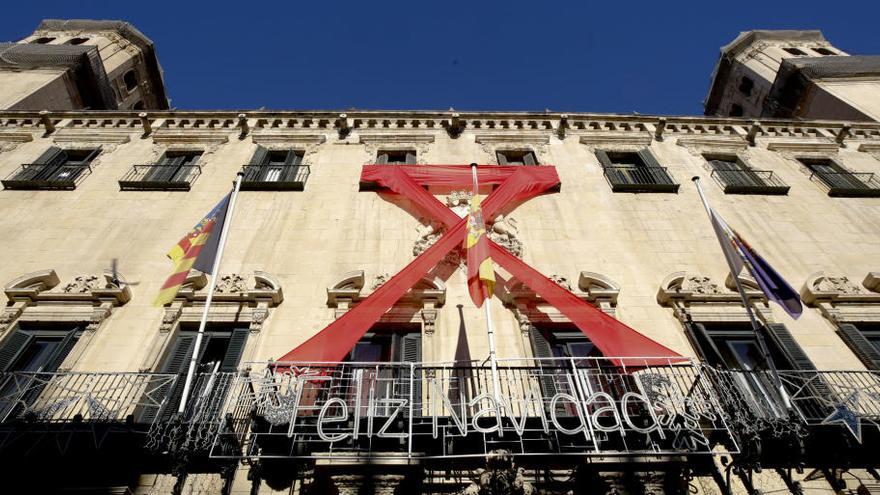 La fachada del Ayuntamiento de Alicante luce hoy con un lazo rojo con motivo del Día mundial de la lucha contra el Sida