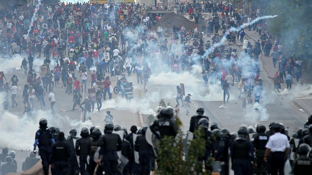 Opositores y policía se enfrentan cerca del Estadio Nacional de Tegucigalpa antes de la toma de posesión del presidente de Honduras, Juan Orlando Hernández