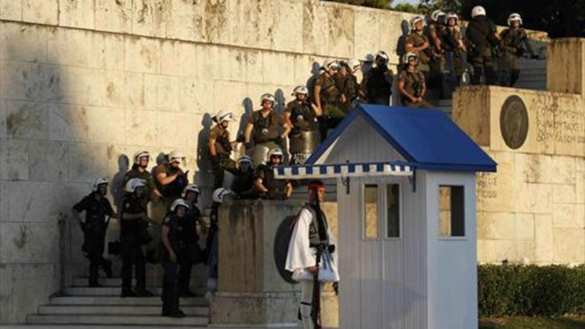 Agentes antidisturbios griegos hacen guardia frente al edificio del Parlamento, ayer.