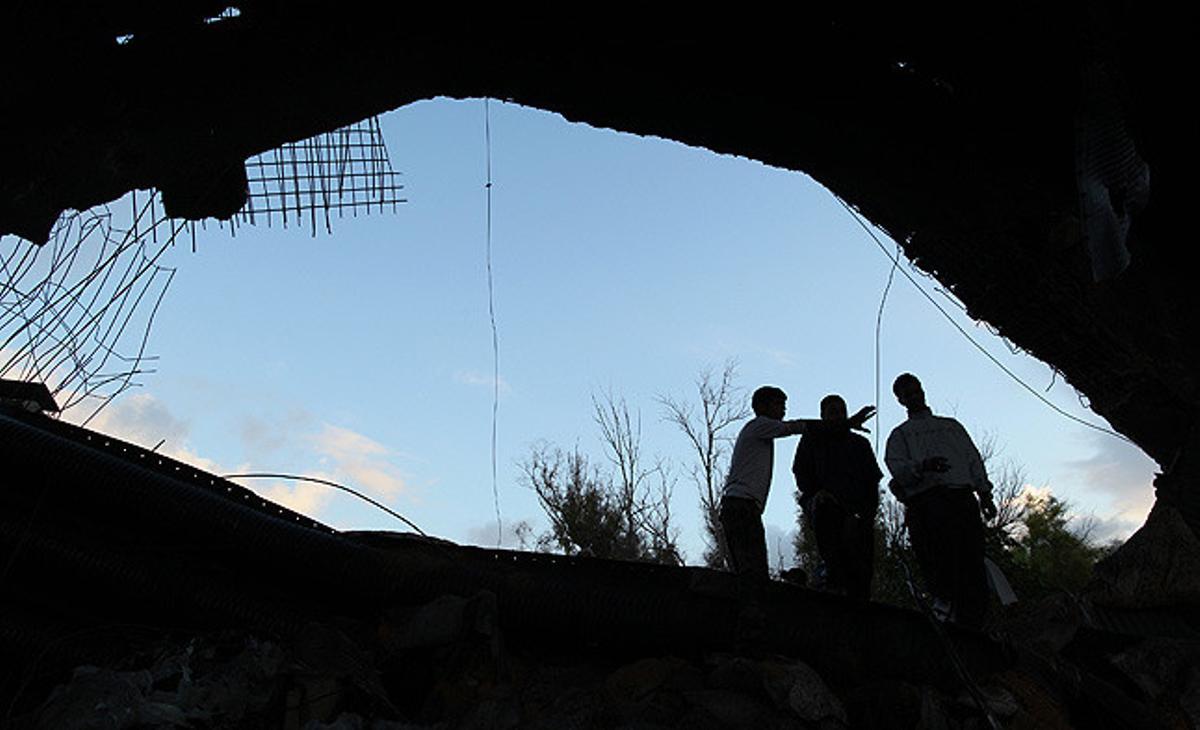 Un equip de tècnics libis en eliminació de mines inspeccionen els danys en una zona de Trípoli després de l’explosió controlada d’una bomba de l’OTAN.