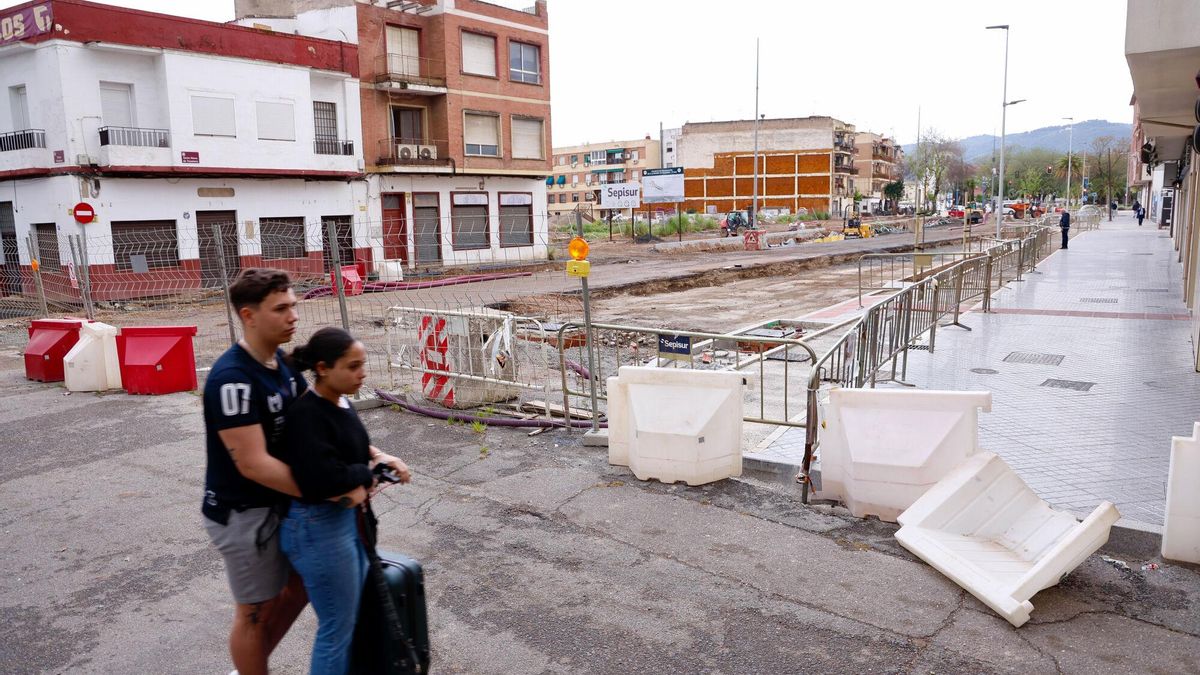 Dos personas caminan junto a las obras en la avenida de Trassierra.