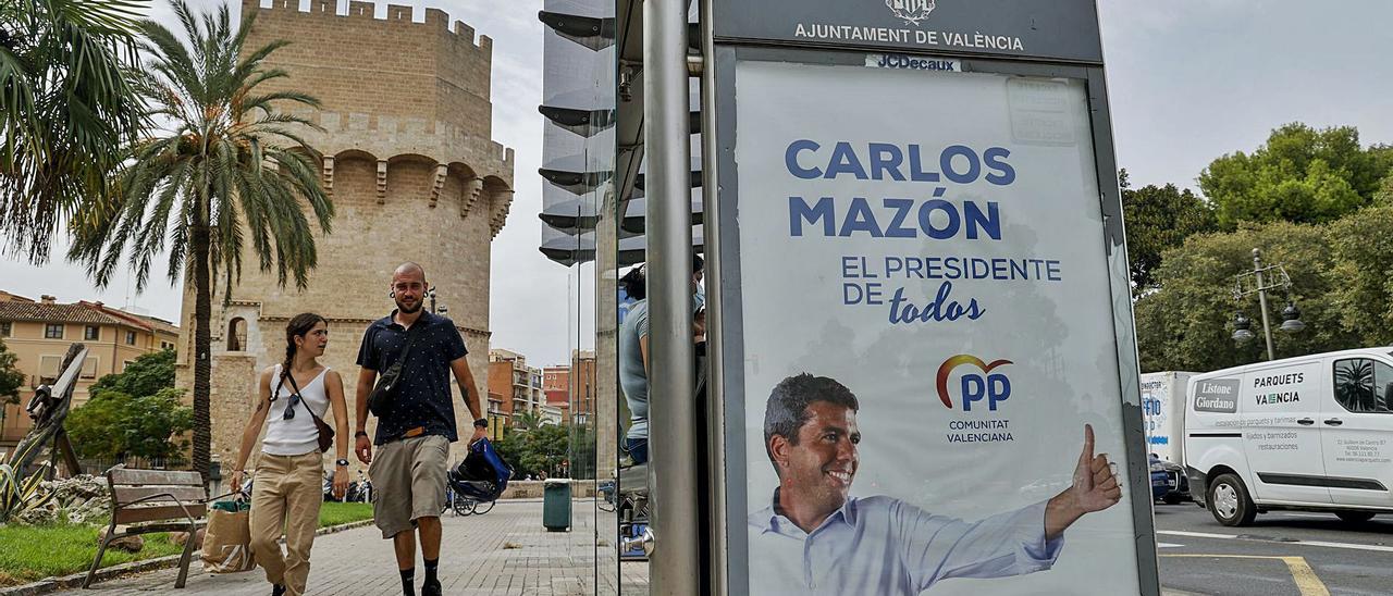 Un cartel de Carlos Mazón en una marquesina junto a las Torres de Serranos en València. | FERNANDO BUSTAMANTE