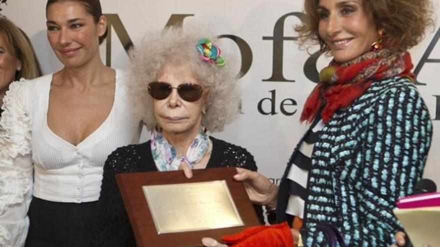 Naty Abascal recibe de manos de la duquesa de Alba una placa por la promoción de la moda flamenca.