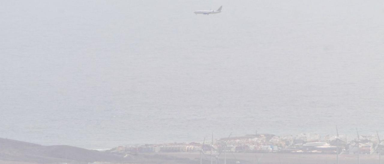 Vista de un avión aterrizando en Gran Canaria, difuminado por la intensa calima.  | | JUAN CASTRO