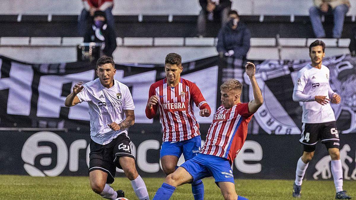 César y Berto pugnan por un balón con un jugador del Burgos.