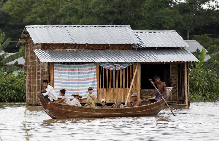 A man rows his boat in a flooded village outside Zalun Township, Irrawaddy Delta