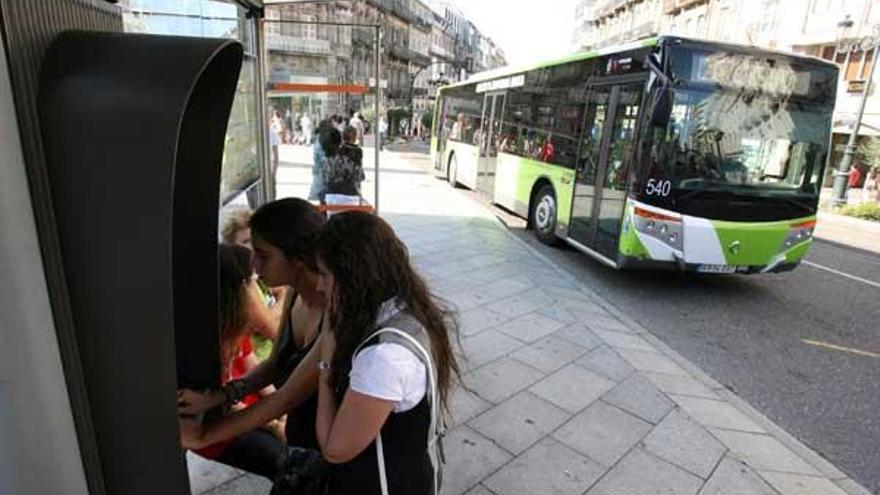 Dos jóvenes usan uno de los puntos de acceso a internet disponibles en las paradas de autobús.