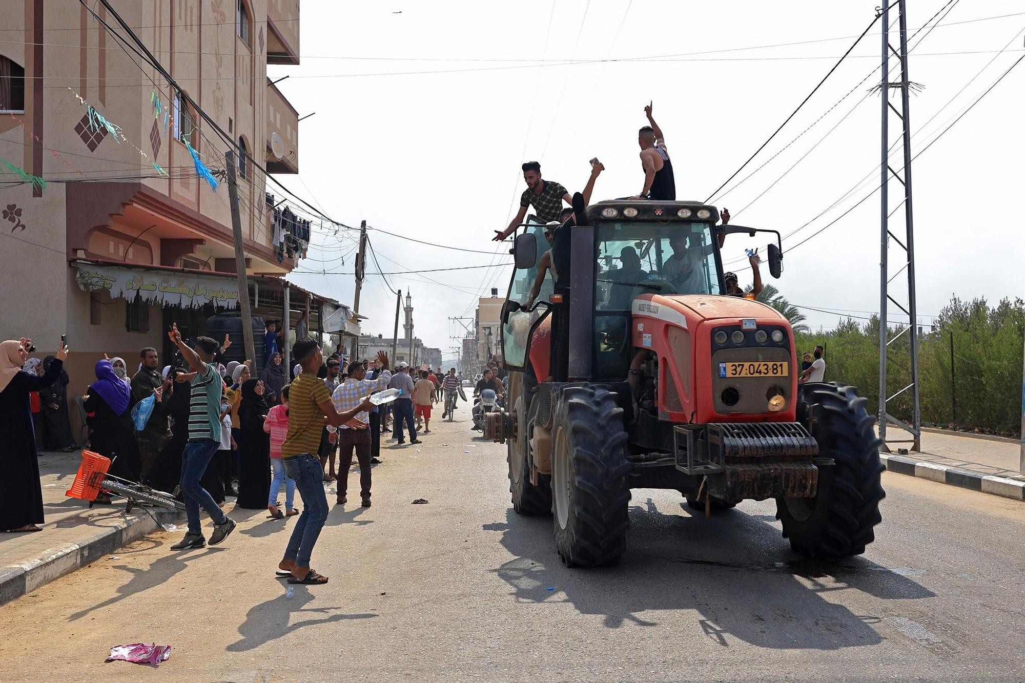 Ciudadanos palestinos conducen un tractor israelí tras cruzar la valla fronteriza con Israel desde Khan Yunis en la parte suroeste de la Franja de Gaza.