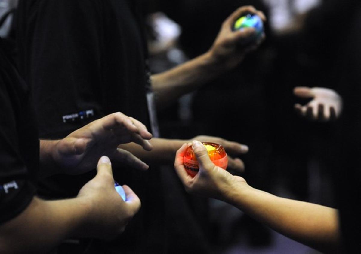 Participantes de la feria de Los Angeles testean el Dynaflex International’s Powerball Gyro, diseñado para calentar los músculos de los jugadores.