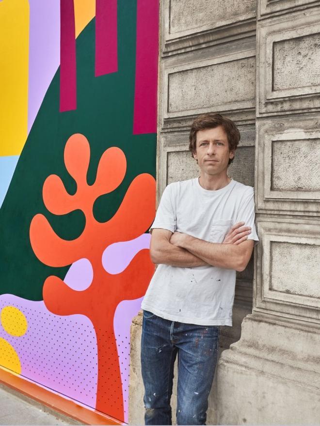 El artista Luckylefthand posando con su obra en París