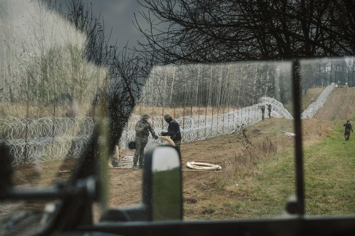 Soldados del ejército polaco arreglan bobinas de alambre de púas en una valla a lo largo de la frontera polaca, con el enclave ruso de Kaliningrado, cerca de Zerdziny, Polonia