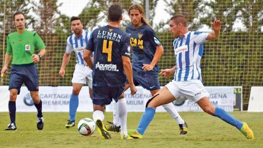 Chando lucha ayer por el balón con varios jugadores del UCAM Murcia.