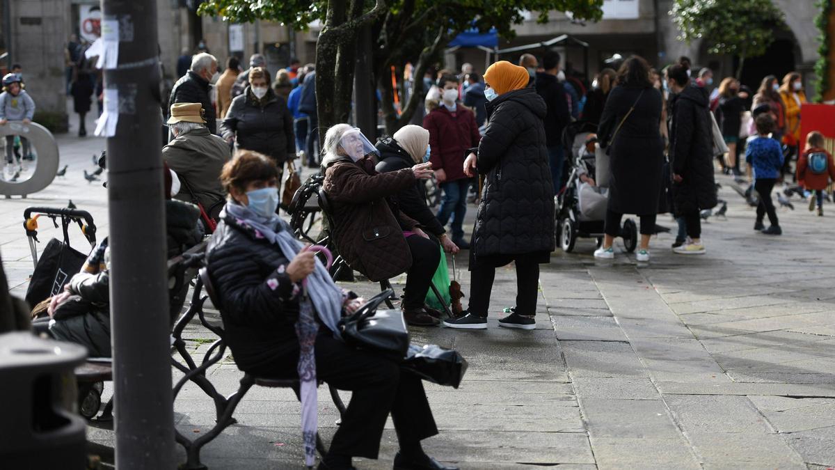 Gente mayor en los bancos de la plaza de la Ferrería, en Pontevedra.