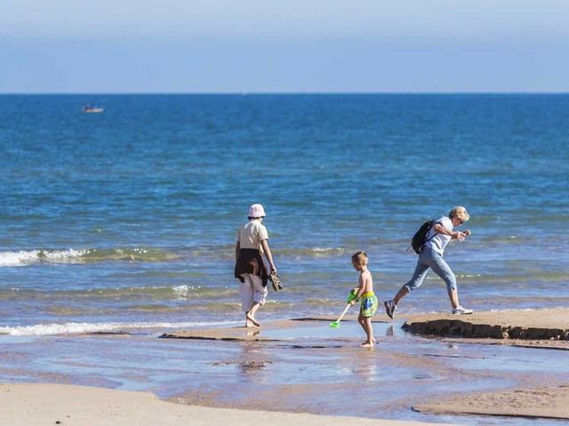 Paseantes en la playa de Oliva.