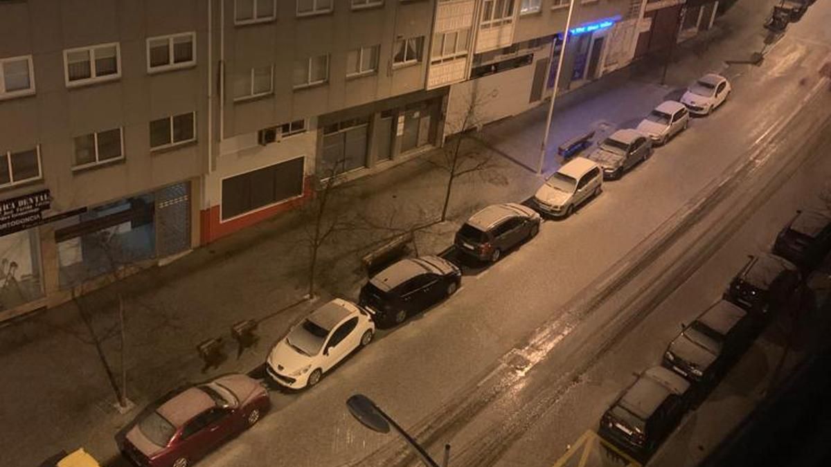 Granizada en A Coruña: Una calle de O Ventorrillo, hoy con la calzada, las aceras y los coches cubiertos de blanco por el granizo.