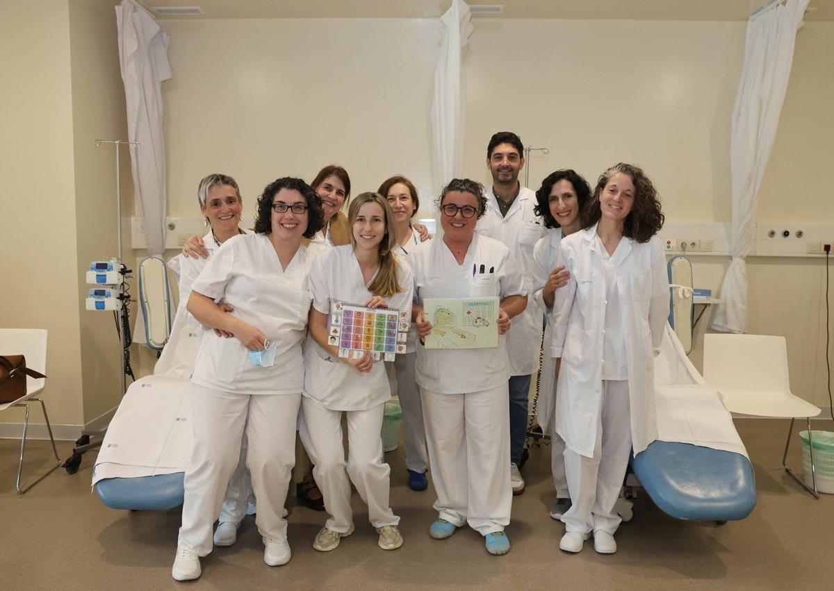 Carmela, enfermera, y sus compañeras, con los pictogramas que desarrollaron para adaptar el tratamiento de quimioterapia al primer paciente autista