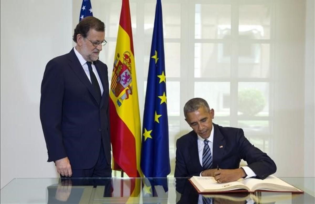 El presidente de los EE. UU. Barack Obama firma en el libro de honor ante la mirada del presidente del Gobierno Mariano Rajoy que lo ha recibido hoy en el palacio de la Moncloa en la primera visita oficial del mandatario estadounidense a España