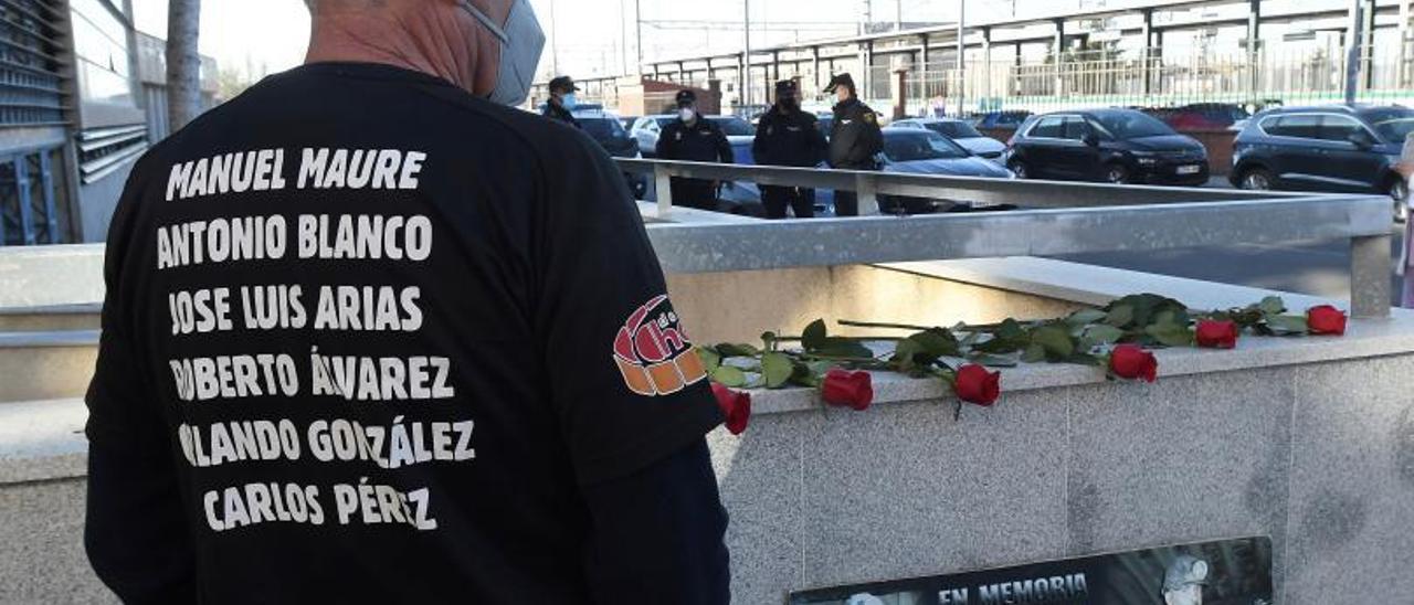 Un hombre porta una camiseta con los nombres de los mineros fallecidos hace un año, cuando se suspendió el juicio en León. | J. C. / Efe