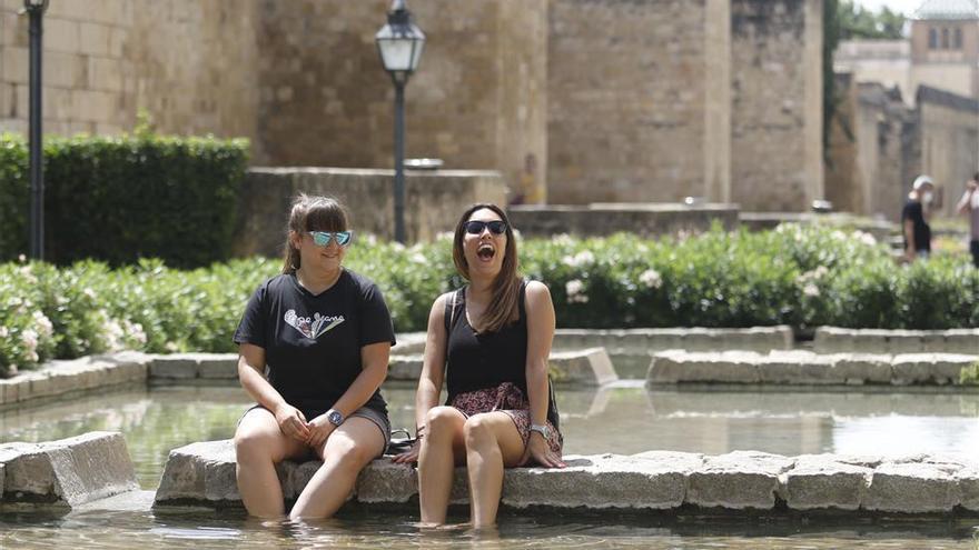 Dos mujeres se refrescan en una fuente de Córdoba.