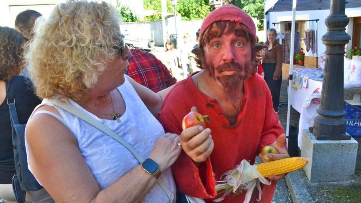 Público comprando en un puesto. Debajo, Carmen Martínez, sorprendida por un trasgu. A la derecha, los «Avellaneros del año», Iván González e Irene Medina, en la ofrenda de la avellana a la Virgen de la Cueva, ayer, en su  santuario. | Ana Paz Paredes / Florentino Carrión