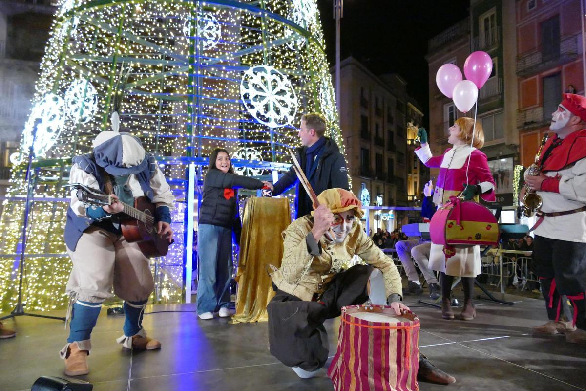 Masquef i una nena de la coral encenent la il·luminació de Nadal